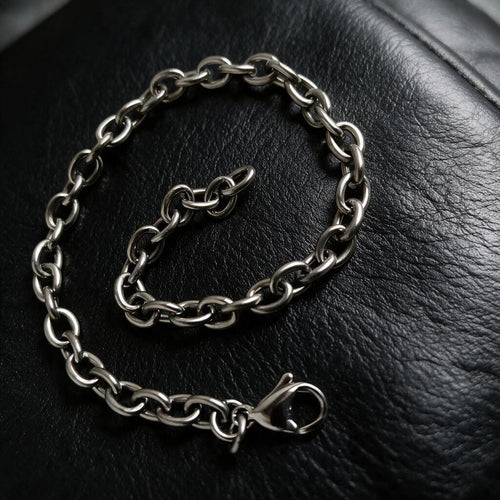 VLKRY - Pure Titanium Jewelry Apex Armband mit polierten ovalen Gliedern aus reinem Titan auf schwarzem Leder.