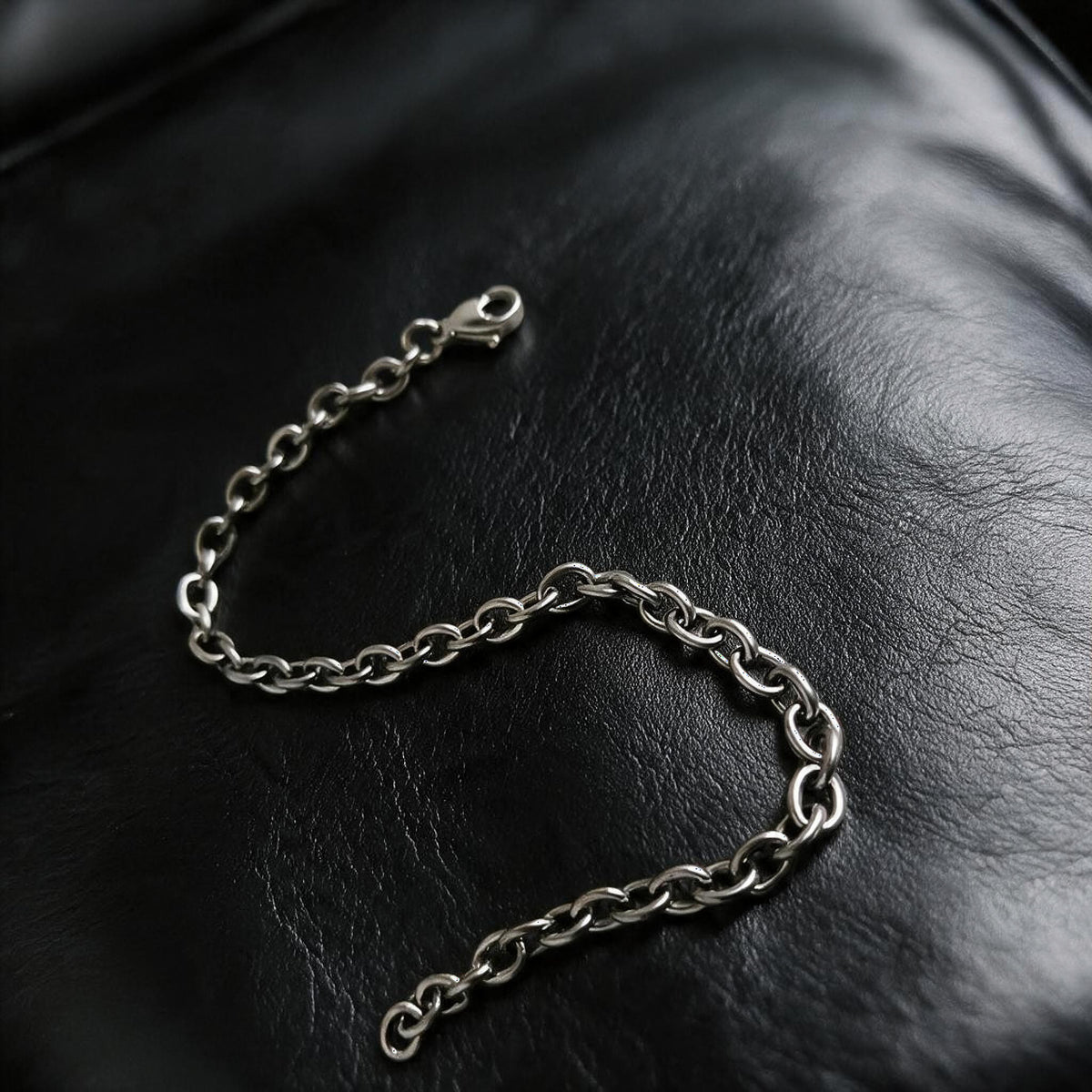 VLKRY - Pure Titanium Jewelry Apex Armband mit ovalen Gliedern aus poliertem, rostfreiem Titan auf schwarzem Leder.