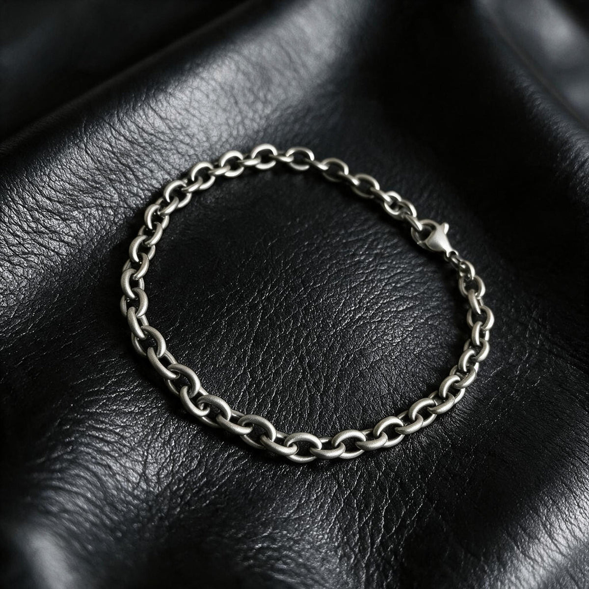 VLKRY - Pure Titanium Jewelry Apex Armband mit ovalen Gliedern aus reinem, hypoallergenem Titan auf schwarzem Leder.
