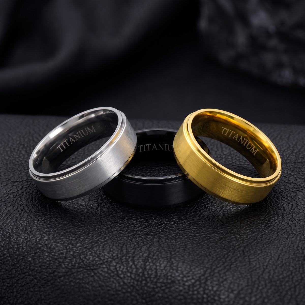 VLKRY - Pure Titanium Jewelry Ring-Set in Silber, Schwarz und Gold mit gebürsteter Oberfläche auf schwarzem Leder