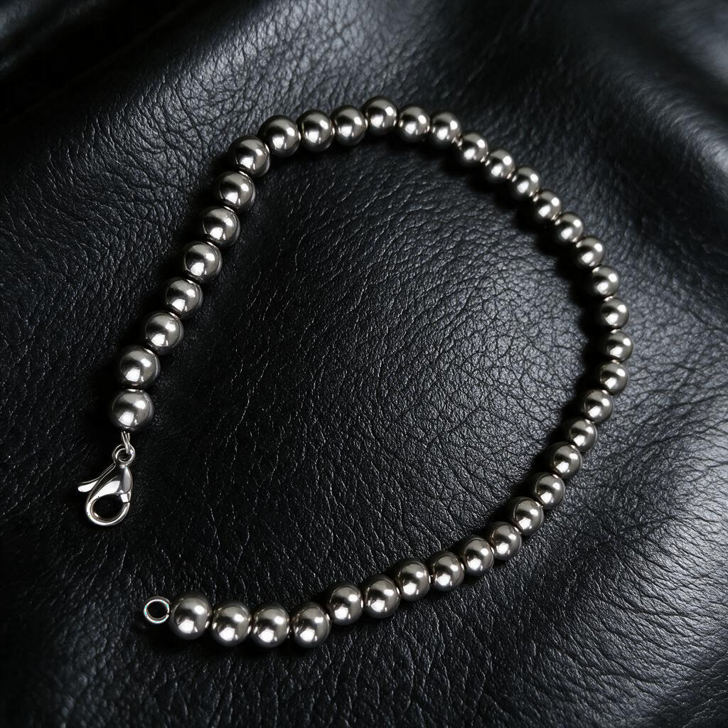 VLKRY - Pure Titanium Jewelry Pearl Armband aus silbernen 5mm Titanperlen auf schwarzem Lederhintergrund