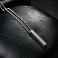 VLKRY - Pure Titanium Jewelry Vertex Halskette mit vertikalem Stab-Anhänger aus reinem Titan auf schwarzem Leder.
